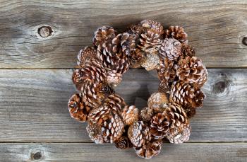 Real pine cone wreath for the Christmas season on rustic wooden boards