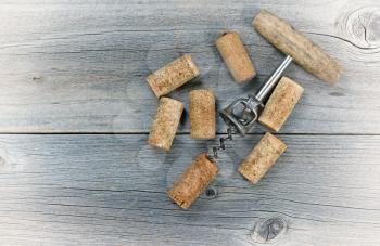 Vintage concept of several used wine corks and opener on rustic wooden boards. 