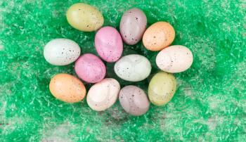 colorful eggs on artificial green grass for Easter Background 