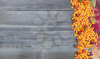 Halloween candy with autumn leaves on rustic wooden boards