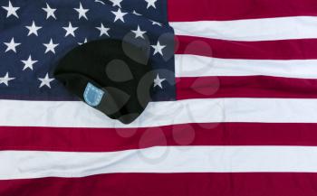 Waving American flag with military beret for happy memorial or Independence Day background concept 
