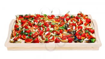 Lot of canape with shrimp, caviar, strawberries and other on wooden tray isolated on white background