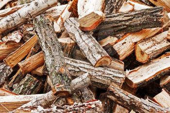 Dry chopped firewood logs in pile. Nature background.