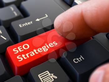 SEO Strategies - Search Engine Optimization - Written on Red Keyboard Key. Male Hand Presses Button on Black PC Keyboard. Closeup View. Blurred Background. 3D Render.