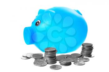 Plastic blue piggy bank with quarters around it isolated on white