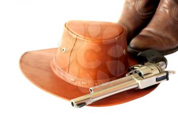 Leather cowboy hat wit boots and a handgun isolated on white