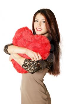 Young beautiful woman holding a heart-shaped pillow