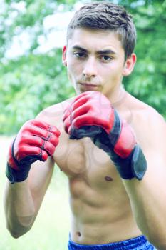 Kickboxer in red gloves engaged on the nature