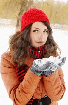 A young woman holding a bunch of snow