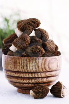 Fresh morel mushrooms on a wooden plate