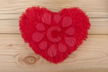 Fluffy heart on wooden background.