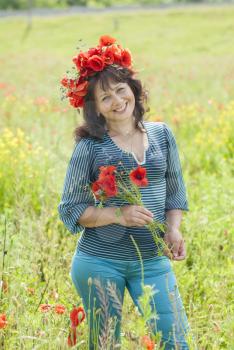 Woman in a field with poppy flowers.