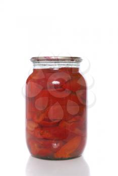 Canned red pepper in a glass jar on a white background.