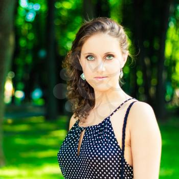 Spring beautiful girl portrait. Pretty young caucasian woman in dress at the park outdoors