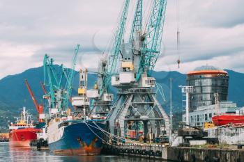 Batumi, Adjara, Georgia. Old Barge Freight Ship Tanker And Heavy Loading Cranes Jib In Port Dock