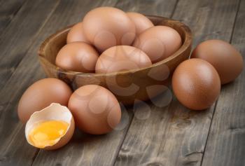 eggs in a wooden bowl on the table from the old boards broken  egg shell and yolk