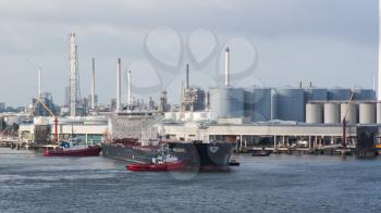 ROTTERDAM, THE NETHERLANDS - JUNE 22: Two tugboats manoeuvring an oil tanker in the dutch harbor of Rotterdam, Rotterdam, June 22, 2012