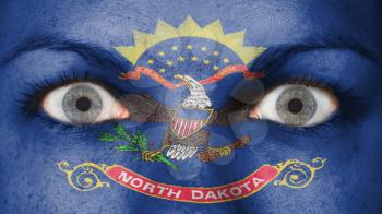 Close up of eyes. Painted face with flag of North Dakota