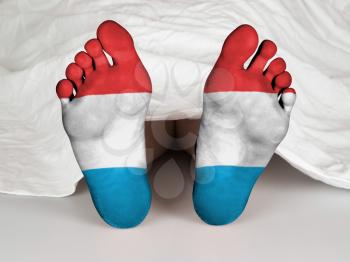 Feet with flag, sleeping or death concept, flag of Luxembourg