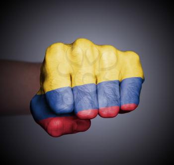 Front view of punching fist on gray background, flag of Colombia