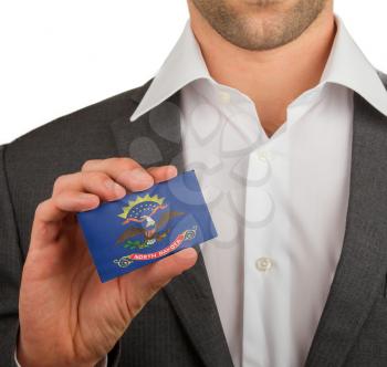Businessman is holding a business card, flag of North Dakota