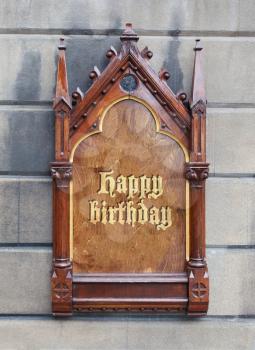 Decorative wooden sign hanging on a concrete wall - Happy birthday