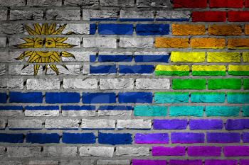 Dark brick wall texture - coutry flag and rainbow flag painted on wall - Uruguay