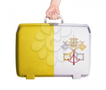 Used plastic suitcase with stains and scratches, printed with flag, Vatican City
