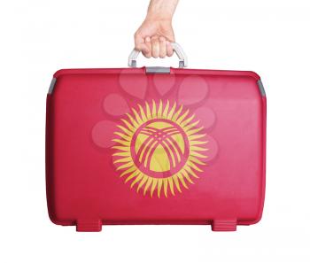Used plastic suitcase with stains and scratches, printed with flag, Kyrgyzstan