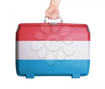 Used plastic suitcase with stains and scratches, printed with flag, Luxembourg