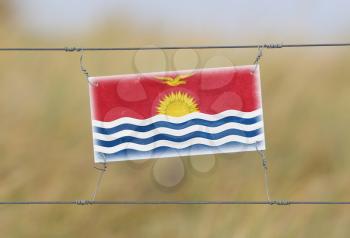 Border fence - Old plastic sign with a flag - Kiribati