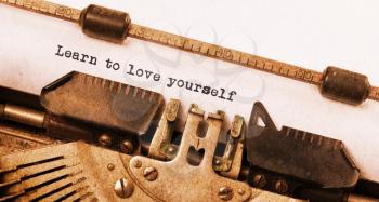 Vintage typewriter, old rusty, warm yellow filter, learn to love yourself
