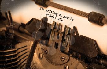 Close-up of an old typewriter with paper, selective focus, I'm writing to you in behalf of