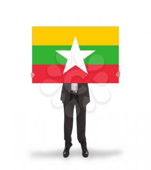 Businessman holding a big card, flag of Myanmar, isolated on white