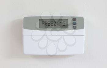 Vintage digital thermostat hanging on a white wall - Covert in dust - Freezing