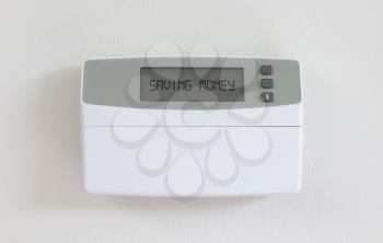 Vintage digital thermostat hanging on a white wall - Covert in dust - Saving money