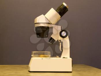 Old simple microscope isolated on a table