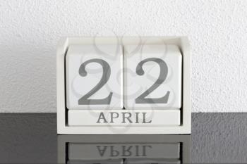 White block calendar present date 22 and month April on white wall background