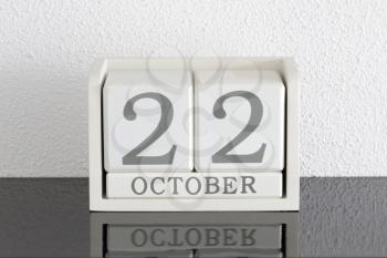 White block calendar present date 22 and month October on white wall background