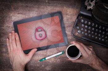 Tablet on a desk, concept of data protection, red