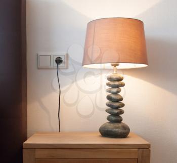 Modern table lamp on a bedside table, lamp is on