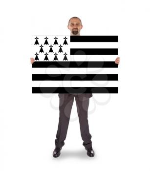 Smiling businessman holding a big card, flag of Brittany, isolated on white