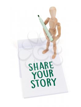 Wooden mannequin writing in a scrapbook - Share your story