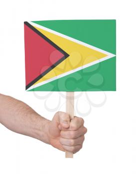 Hand holding small card, isolated on white - Flag of Guyana