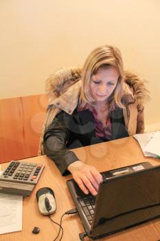 The woman heardly working with a computer at office