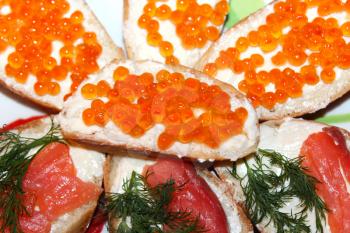 a lot of sandwiches with red caviar and red fish