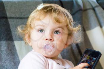 Cute baby girl with new mobile phone