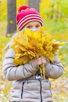 Photo of girl with bouquet from sheets in autumn