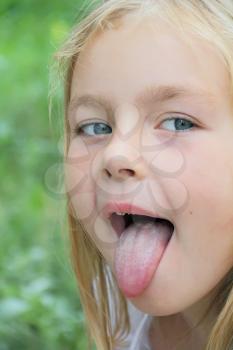 Portrait of small girl with put out tongue