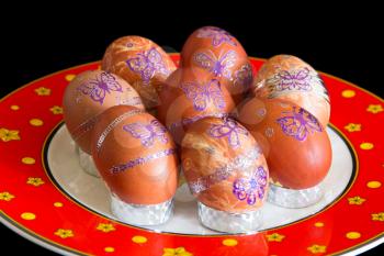 Easter eggs with butterflies on red plate